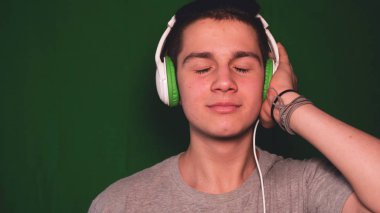 Bir kromatinin arka planı, genç bir adam (çocuk) farklı duygular gösterir. Konsept: Yeşil arka plan, Chroma Key, Gerçek duygular, Fighter, Like, Fashion, Blonde.