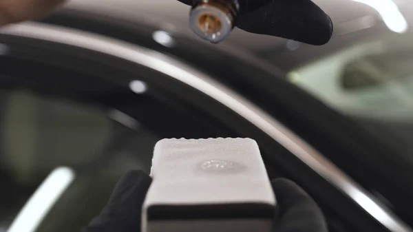 Genç bir profesyonel işçi kırmızı seramik lambalar kurar, bir araba atölyesi, araba yıkama.