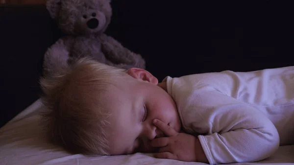 Küçük oğlu, tatlı tatlı yatakta uyur, baba oğlu yatırıyor.