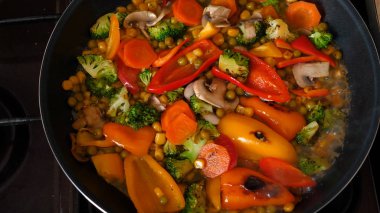 Lezzetli taze sebzeler tavada pişirilir, evdeki vejetaryenler için yemek. Sebze, Biyolojik Ürün, Mantar, Brokoli, Renkli Lahana, Havuç, Mısır, Paprika.