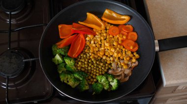 Lezzetli taze sebzeler tavada pişirilir, evdeki vejetaryenler için yemek. Sebze, Biyolojik Ürün, Mantar, Brokoli, Renkli Lahana, Havuç, Mısır, Paprika.