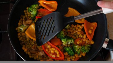 Lezzetli taze sebzeler tavada pişirilir, evdeki vejetaryenler için yemek. Sebze, Biyolojik Ürün, Mantar, Brokoli, Renkli Lahana, Havuç, Mısır, Paprika.