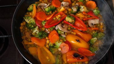 Lezzetli taze sebzeler tavada pişirilir, evdeki vejetaryenler için yemek. Sebze, Biyolojik Ürün, Mantar, Brokoli, Renkli Lahana, Havuç, Mısır, Paprika.