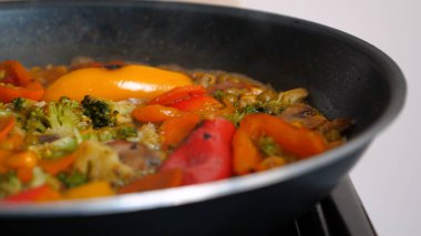 Lezzetli taze sebzeler tavada pişirilir, evdeki vejetaryenler için yemek. Sebze, Biyolojik Ürün, Mantar, Brokoli, Renkli Lahana, Havuç, Mısır, Paprika.