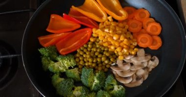 Lezzetli taze sebzeler tavada pişirilir, evdeki vejetaryenler için yemek. Sebze, Biyolojik Ürün, Mantar, Brokoli, Renkli Lahana, Havuç, Mısır, Paprika.