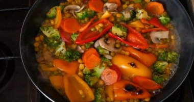 Lezzetli taze sebzeler tavada pişirilir, evdeki vejetaryenler için yemek. Sebze, Biyolojik Ürün, Mantar, Brokoli, Renkli Lahana, Havuç, Mısır, Paprika.