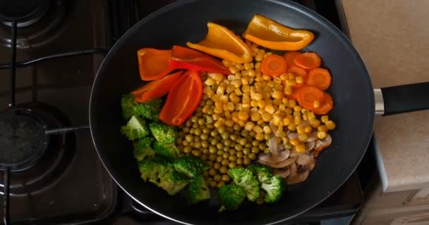 おいしい新鮮な野菜は 家庭で菜食主義者のための食べ物である鍋で煮込まれています バイオ製品 キノコ ブロッコリー カラーキャベツ ニンジン トウモロコシ パプリカ — ストック動画