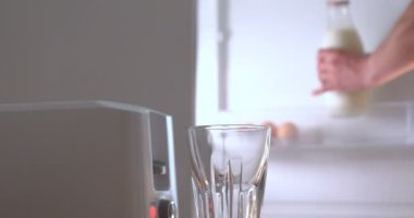 Mutfakta, bir erkek (kız) buzdolabından yiyecek çıkarır ve tost makinesinin yanına kahvaltı hazırlar, hazır ekmek kızartma makineleri çıkarılır. Ev yapımı yemek, rahatlık, kahvaltı, ağır çekim kavramı.