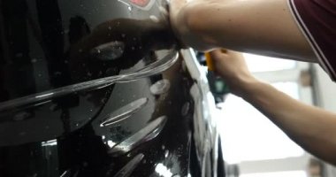 Ön (arka) far ve bamper üzerinde PPF kurulum işlemine yakın. PPF çizilmelere ve taş yongaları boya korumak bir boya koruma filmi. Kavramı: film, Araba, servis, Slow Mo