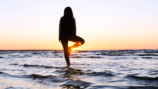 Молодая Женщина Фоне Заката Солнца Берегу Моря Делает Упражнения Выполняя — стоковое фото