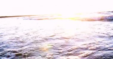 Sahilde güzel ateşli günbatımı gökyüzü. Doğanın kompozisyonu, kumlu bir plajda deniz dalgaları.