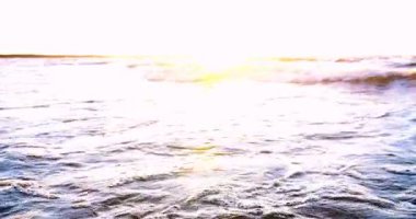 Sahilde güzel ateşli günbatımı gökyüzü. Doğanın kompozisyonu, kumlu bir plajda deniz dalgaları.