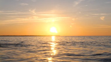 Sahilde güzel ateşli günbatımı gökyüzü. Doğanın kompozisyonu, kumlu bir plajda deniz dalgaları.