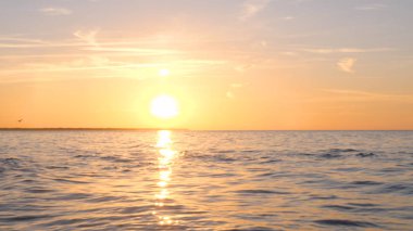 Sahilde güzel ateşli günbatımı gökyüzü. Doğanın kompozisyonu, kumlu bir plajda deniz dalgaları.