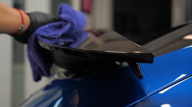 Araba yıkamacıdaki bir kadın özel kimya, giysi, sünger ve fırça kullanarak arabanın tüm parçalarını kuru temizlemeye verir. Tam araba temizliği, kuru temizleme, profesyonel hizmet. Araba, iş.