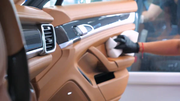 Araba yıkamacıdaki bir kadın özel kimya, giysi, sünger ve fırça kullanarak arabanın tüm parçalarını kuru temizlemeye verir. Tam araba temizliği, kuru temizleme, profesyonel hizmet. Araba, iş.