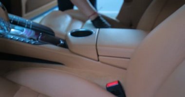 Araba yıkamacıdaki bir kadın özel kimya, giysi, sünger ve fırça kullanarak arabanın tüm parçalarını kuru temizlemeye verir. Tam araba temizliği, kuru temizleme, profesyonel hizmet. Araba, iş.