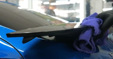 Araba yıkamacıdaki bir kadın özel kimya, giysi, sünger ve fırça kullanarak arabanın tüm parçalarını kuru temizlemeye verir. Tam araba temizliği, kuru temizleme, profesyonel hizmet. Araba, iş.