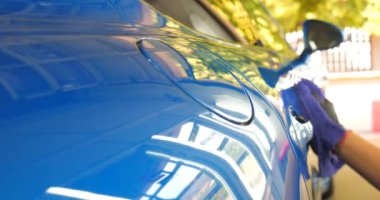 Araba yıkamacıdaki bir kadın özel kimya, giysi, sünger ve fırça kullanarak arabanın tüm parçalarını kuru temizlemeye verir. Tam araba temizliği, kuru temizleme, profesyonel hizmet. Araba, iş.