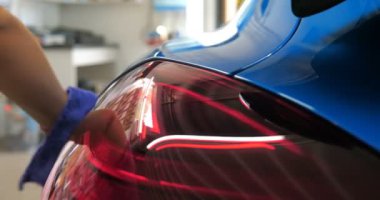 Araba yıkamacıdaki bir kadın özel kimya, giysi, sünger ve fırça kullanarak arabanın tüm parçalarını kuru temizlemeye verir. Tam araba temizliği, kuru temizleme, profesyonel hizmet. Araba, iş.