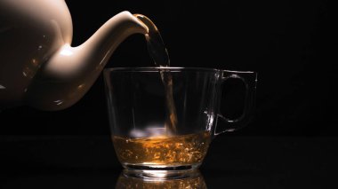 Çay Hazırlama Süreci. Çay seremonisi, bir fincan taze Briar, karanlık bir ruh hali. Sıcak su buharla doldurulur. Kavram: Sıcak, Buhar, Seramik, Kupa.