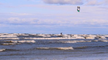 Rüzgarda profesyonel sörfçü okyanusa denizde rüzgar hazırlanıyor. Rüzgar sörfçüsü fırtınada dalgayı yakalar. Konsept: Spor, Yaşam Tarzı, Yönetim Kurulu, Dalgalar, Yavaş Hareket
