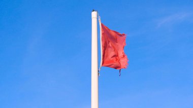 Denizle kırmızı bayrak, sinyal uyarısı. Denizle kırmızı bayrak, sahilde sinyal uyarısı. Konsept: Uyarı, Deniz, Plaj, Yavaş hareket.