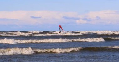 Rüzgarda profesyonel sörfçü okyanusa denizde rüzgar hazırlanıyor. Rüzgar sörfçüsü fırtınada dalgayı yakalar. Konsept: Spor, Yaşam Tarzı, Yönetim Kurulu, Dalgalar, Yavaş Hareket