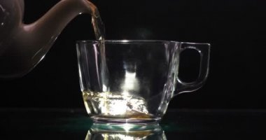 Çay Hazırlama Süreci. Çay seremonisi, bir fincan taze Briar, karanlık bir ruh hali. Sıcak su buharla doldurulur. Kavram: Sıcak, Buhar, Seramik, Kupa.