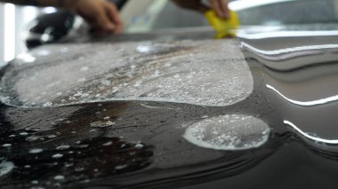 Ön far ve kaputta Ppf montaj işlemine yakın. Ppf, boyayı çizilmelerden ve taş yongalarından koruyan bir Boya Koruma Filmidir. Konsept: Koruma, Koruma, Araba, Yeni, İş.