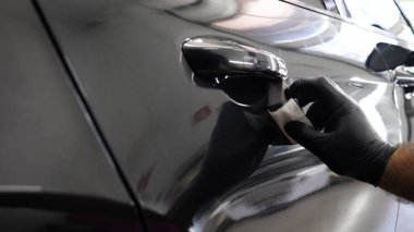 Personel iş yerinde kimyasal koruyucu giysiler giyer. Otomobil endüstrisi. Seramik kaplama ile oto yıkama ve kaplama işi. Vernikleri arabaya püskürtüyor. Konsept: Araba koruyucu, Servis, Shine.