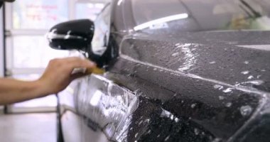 Ön far ve kaputta Ppf montaj işlemine yakın. Ppf, boyayı çizilmelerden ve taş yongalarından koruyan bir Boya Koruma Filmidir. Konsept: Koruma, Koruma, Araba, Yeni, İş.