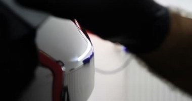 Personel iş yerinde kimyasal koruyucu giysiler giyer. Otomobil endüstrisi. Seramik kaplama ile oto yıkama ve kaplama işi. Vernikleri arabaya püskürtüyor. Konsept: Araba koruyucu, Servis, Shine.