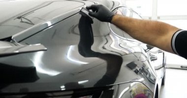 Personel iş yerinde kimyasal koruyucu giysiler giyer. Otomobil endüstrisi. Seramik kaplama ile oto yıkama ve kaplama işi. Vernikleri arabaya püskürtüyor. Konsept: Araba koruyucu, Servis, Shine.
