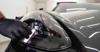 Personel iş yerinde kimyasal koruyucu giysiler giyer. Otomobil endüstrisi. Seramik kaplama ile oto yıkama ve kaplama işi. Vernikleri arabaya püskürtüyor. Konsept: Araba koruyucu, Servis, Shine.
