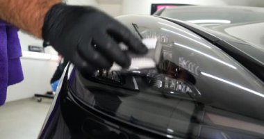 Personel iş yerinde kimyasal koruyucu giysiler giyer. Otomobil endüstrisi. Seramik kaplama ile oto yıkama ve kaplama işi. Vernikleri arabaya püskürtüyor. Konsept: Araba koruyucu, Servis, Shine.