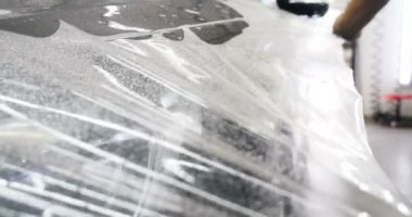 Ön far ve kaputta Ppf montaj işlemine yakın. Ppf, boyayı çizilmelerden ve taş yongalarından koruyan bir Boya Koruma Filmidir. Konsept: Koruma, Koruma, Araba, Yeni, İş.