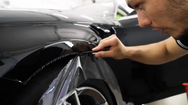 Ön far ve kaputta Ppf montaj işlemine yakın. Ppf, boyayı çizilmelerden ve taş yongalarından koruyan bir Boya Koruma Filmidir. Konsept: Koruma, Koruma, Araba, Yeni, İş.