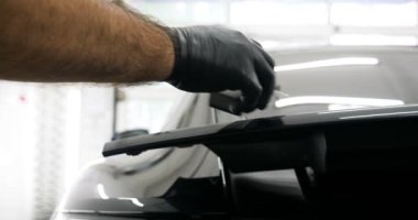 Personel iş yerinde kimyasal koruyucu giysiler giyer. Otomobil endüstrisi. Seramik kaplama ile oto yıkama ve kaplama işi. Vernikleri arabaya püskürtüyor. Konsept: Araba koruyucu, Servis, Shine.