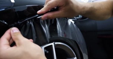 Ön far ve kaputta Ppf montaj işlemine yakın. Ppf, boyayı çizilmelerden ve taş yongalarından koruyan bir Boya Koruma Filmidir. Konsept: Koruma, Koruma, Araba, Yeni, İş.