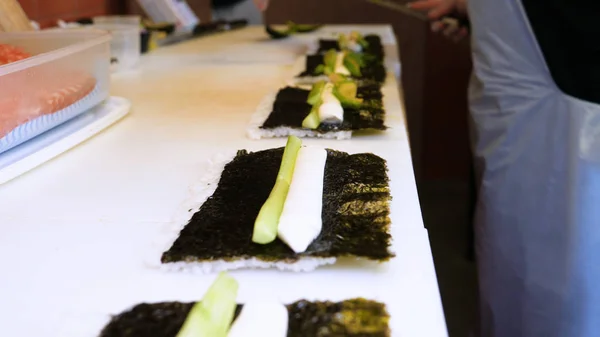 在餐馆厨房里 专业厨师手的特写镜头 戴着透明手套 制作寿司和卷曲 日本传统食品 准备过程 色拉蒙 — 图库照片