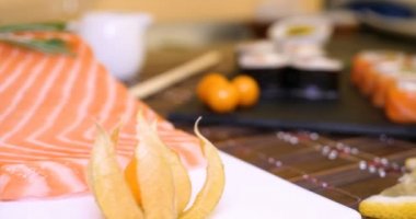 Somon ve Tuna, California Rolls, Maki, soya sos closeup tablo üzerinde Sushi bir dizi hizmet vermiştir. Eller Chopsticks ile suşi yemek.