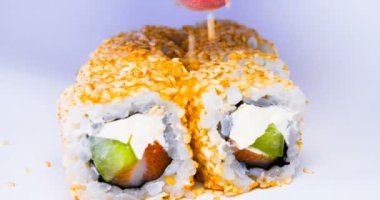 Bir veya daha fazla maki rulo somon, avokado, ton balığı ve salatalık beyaz arka planda izole bir satırda. Pirinç ve Nori ile taze hosomaki parçaları. Suşi rulo ile lezzetli Japon gıda closeup.