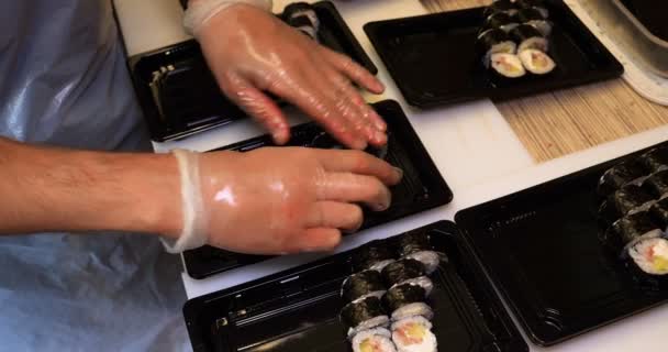 在餐馆厨房里 专业厨师手的特写镜头 戴着透明手套 制作寿司和卷曲 日本传统食品 准备过程 色拉蒙 — 图库视频影像