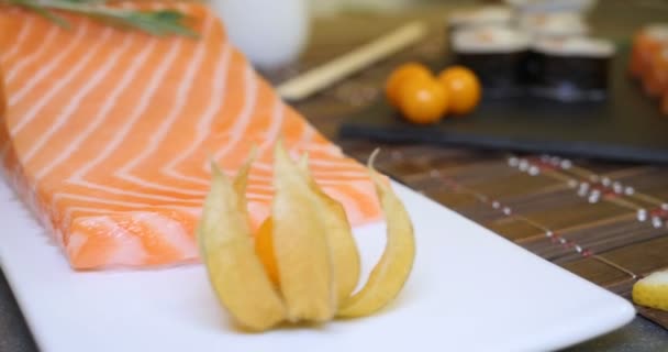 サーモンとマグロ カリフォルニアロールス 醤油クローズアップの寿司セットをテーブルの上に提供 手は箸で寿司を食べる — ストック動画