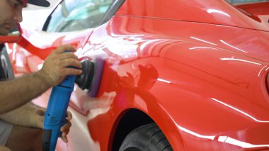 Araba merkezinde (garajda), profesyoneller yeni bir spor araba Lehçe. Lüks araba parlatma. Kavramı: yarış, spor araba, yeni, yavaş hareket, NASCAR, kırmızı, krom kaplama.