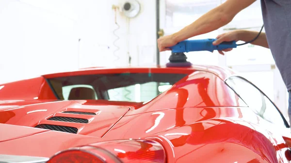 Araba merkezinde (garajda), profesyoneller yeni bir spor araba Lehçe. Lüks araba parlatma. Kavramı: yarış, spor araba, yeni, yavaş hareket, NASCAR, kırmızı, krom kaplama.