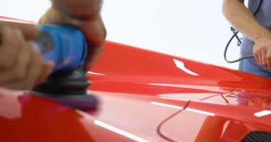Araba merkezinde (garajda), profesyoneller yeni bir spor araba Lehçe. Lüks araba parlatma. Kavramı: yarış, spor araba, yeni, yavaş hareket, NASCAR, kırmızı, krom kaplama.