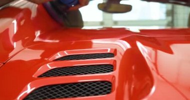 Araba merkezinde (garajda), profesyoneller yeni bir spor araba Lehçe. Lüks araba parlatma. Kavramı: yarış, spor araba, yeni, yavaş hareket, NASCAR, kırmızı, krom kaplama.