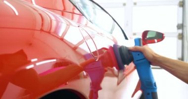 Araba merkezinde (garajda), profesyoneller yeni bir spor araba Lehçe. Lüks araba parlatma. Kavramı: yarış, spor araba, yeni, yavaş hareket, NASCAR, kırmızı, krom kaplama.